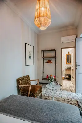 a living room with a table and a chair at Riad VUE D'AGDAL in Marrakech