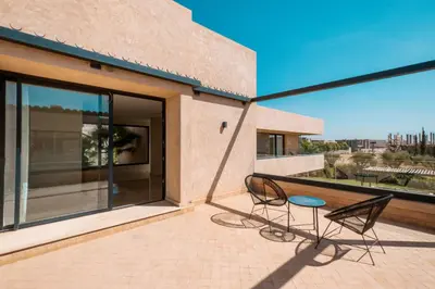a patio with two chairs and a balcony with a view at Villa Hicham Golf Marrakech in Marrakech