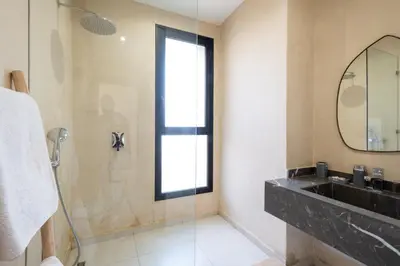 a bathroom with a shower and a sink and a mirror at Villa Hicham Golf Marrakech in Marrakech