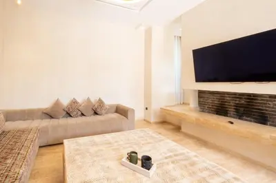 a living room with a couch and a flat screen tv at Villa Hicham Golf Marrakech in Marrakech
