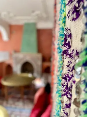 a person sitting in a living room with a fireplace at Riad Flottement Des Songes in Marrakech
