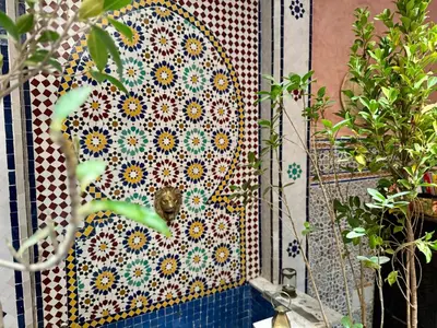 a mosaic tile on the side of a wall at Riad Flottement Des Songes in Marrakech