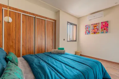 a bedroom with a large blue bed and a wooden closet at Beau Studio au hub de Gueliz in Marrakech