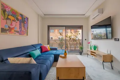 a living room with a blue couch and a table at Beau Studio au hub de Gueliz in Marrakech