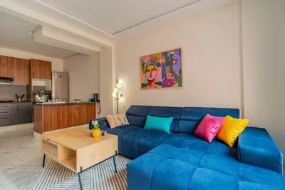 a living room with a blue couch with colorful pillows at Beau Studio au hub de Gueliz in Marrakech