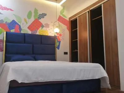 a bedroom with a blue bed and a colorful wall at Beau Studio au hub de Gueliz in Marrakech