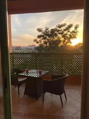 a table and chairs on a balcony with a view at Cosy Appartement Avec Piscine in Marrakech