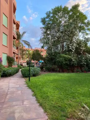 a sidewalk in a park next to a building at Cosy Appartement Avec Piscine in Marrakech