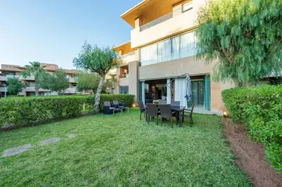 a yard with tables and chairs in front of a building at Poolside Apartment's-Green View in Marrakech