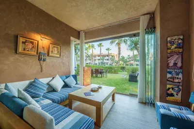 a living room with a blue couch and a table at Poolside Apartment's-Green View in Marrakech