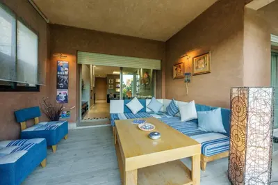 a living room with a blue couch and a wooden table at Poolside Apartment's-Green View in Marrakech