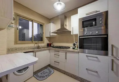 a kitchen with a stove and a microwave at Poolside Apartment's-Green View in Marrakech