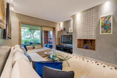 a living room with a couch and a tv at Poolside Apartment's-Green View in Marrakech