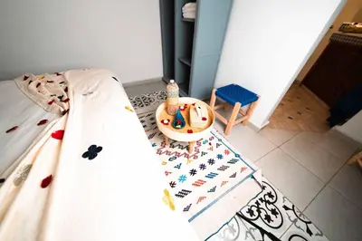 a bedroom with a bed and a table and a rug at Riad Kiyanjana in Marrakech