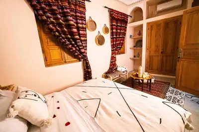 a bedroom with a bed in a room at Riad Kiyanjana in Marrakech