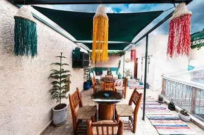 an outdoor patio with a table and chairs at Riad Kiyanjana in Marrakech