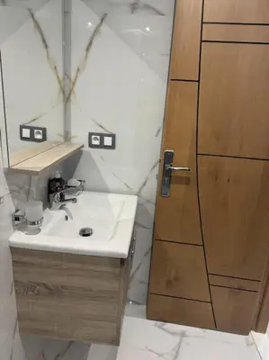 a bathroom with a sink and a wooden door at appartement à Gueliz in Marrakech