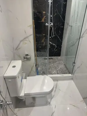 a white bathroom with a shower and a toilet at appartement à Gueliz in Marrakech
