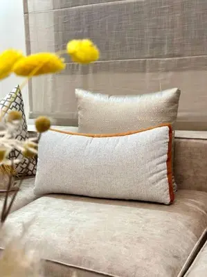 a white pillow sitting on a couch with yellow flowers at appartement à Gueliz in Marrakech