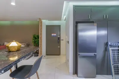 a kitchen with a stainless steel refrigerator and a table at Luxury studio Center Gueliz in Marrakech