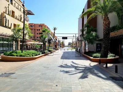 an empty street with palm trees and buildings at Luxury Place M Avenue in Marrakech