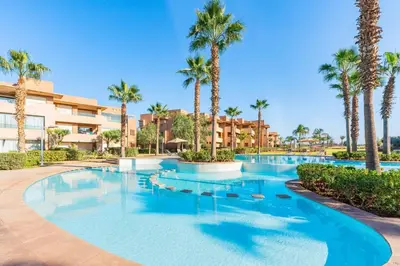 a swimming pool at a resort with palm trees at Relax Front Of Pool-Golf-Atlas in Marrakech