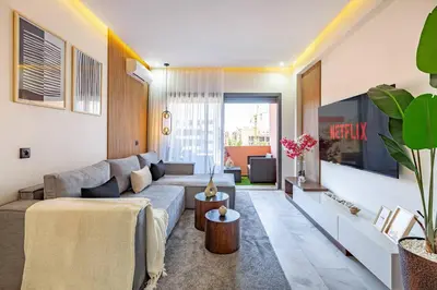 a living room with a couch and a tv at Luxury Apartment Gueliz, Cinema Bedroom Experience in Marrakech