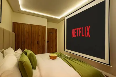 a bedroom with a bed with a television on the wall at Luxury Apartment Gueliz, Cinema Bedroom Experience in Marrakech