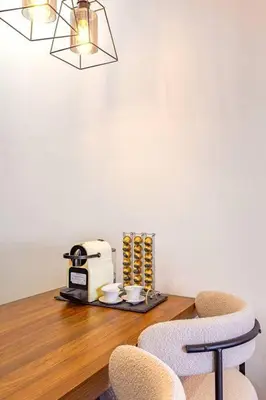 a dining room table with a coffee maker and two chairs at Luxury Apartment Gueliz, Cinema Bedroom Experience in Marrakech
