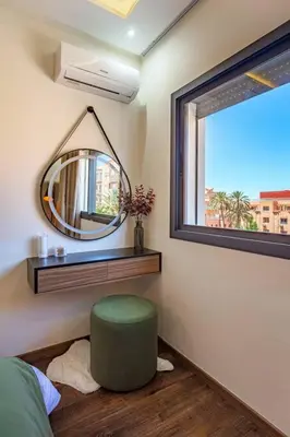 a bedroom with a mirror and a green ottoman at Luxury Apartment Gueliz, Cinema Bedroom Experience in Marrakech