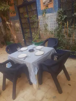 a table with chairs and a white table cloth on it at RIAD DAR KADER D in Marrakech