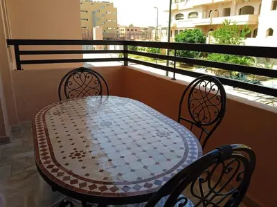 a table and two chairs on a balcony at Appart Premium Village Marrakech in Marrakech