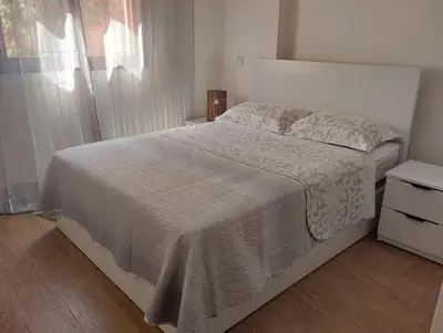 a bedroom with a bed with a white bedspread and a window at Chill Apartment Portes Gueliz in Marrakech