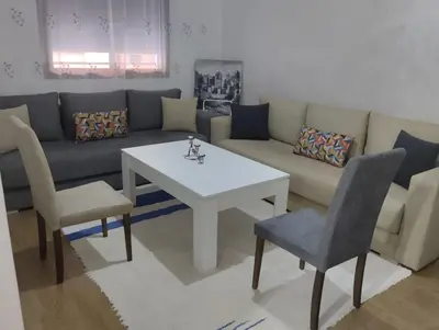 a living room with a couch and a table and chairs at Chill Apartment Portes Gueliz in Marrakech