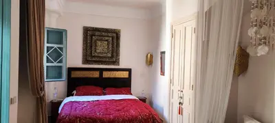 a bedroom with a bed with a red comforter at Marrakech, villa 7 Harmonia, pour 6 personnes avec piscine privée in Marrakech