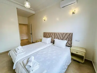 a bedroom with a large bed with white sheets at Spacious Apartment 102m2 3 Bedrooms 2 Bathrooms 8 Guests Elevator Self Check in in Marrakech