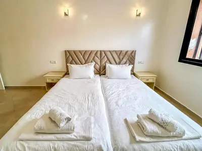a bedroom with two beds with white sheets and towels at Spacious Apartment 102m2 3 Bedrooms 2 Bathrooms 8 Guests Elevator Self Check in in Marrakech