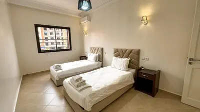 a bedroom with two beds and a window at Spacious Apartment 102m2 3 Bedrooms 2 Bathrooms 8 Guests Elevator Self Check in in Marrakech