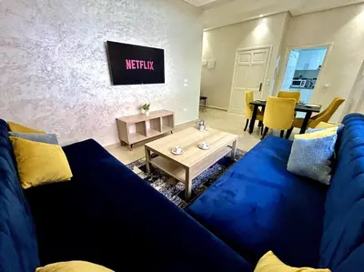 a living room with a blue couch and a table at Marrakech 2 Bedroom Family Apartment in Marrakech