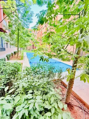 a garden with a swimming pool and plants at Confortable & Spacieux & Au Centre-ville in Marrakech