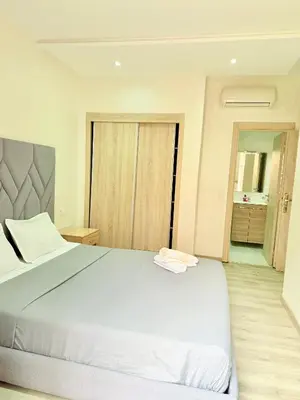 a bedroom with a large white bed and a bathroom at Confortable & Spacieux & Au Centre-ville in Marrakech