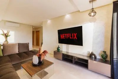 a living room with a television on a wall at Appart View Pool - 3 Rooms - Optical Fiber in Marrakech