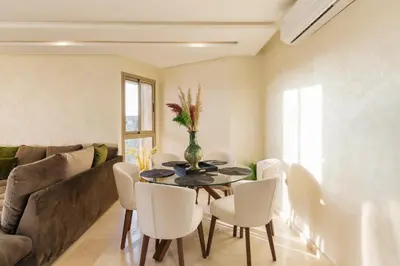 a dining room with a table and white chairs at Appart View Pool - 3 Rooms - Optical Fiber in Marrakech