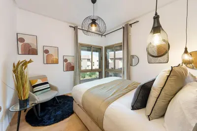 a bedroom with a bed and a table and a window at Appart View Pool - 3 Rooms - Optical Fiber in Marrakech