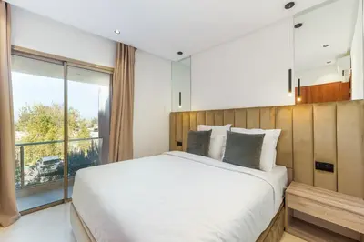 a bedroom with a large bed and a large window at Luxueux appartement prestigia golf/vue piscine in Marrakech