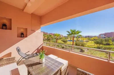 a balcony with a table and chairs and a large window at Luxueux appartement prestigia golf/vue piscine in Marrakech