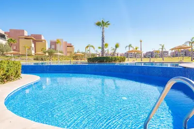 a swimming pool in a resort with palm trees at Luxueux appartement prestigia golf/vue piscine in Marrakech
