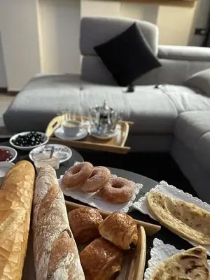 a table topped with different types of bread and pastries at Appartement de luxe à louer in Marrakech