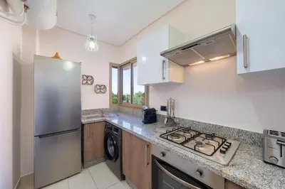 a kitchen with a stainless steel refrigerator and a dishwasher at Green Side Golf 3 B.R Apartment in Marrakech