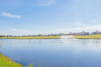 a pond with ducks in the water with a fountain at Green Side Golf 3 B.R Apartment in Marrakech
